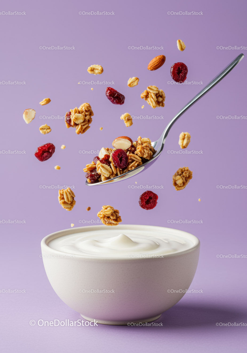 Granola i orzechy wpadające do miski z kremowym jogurtem