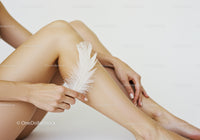 Elegant Female Legs with White Feather on Soft Skin