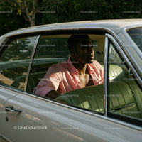 Young Man in Pink Shirt Sitting in Vintage Car on a Sunny Day