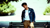 Casual young man posing by park bench outdoors