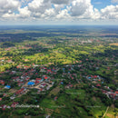 Aerial View of Tropical Village Surrounded by Green Foliage and Farmland