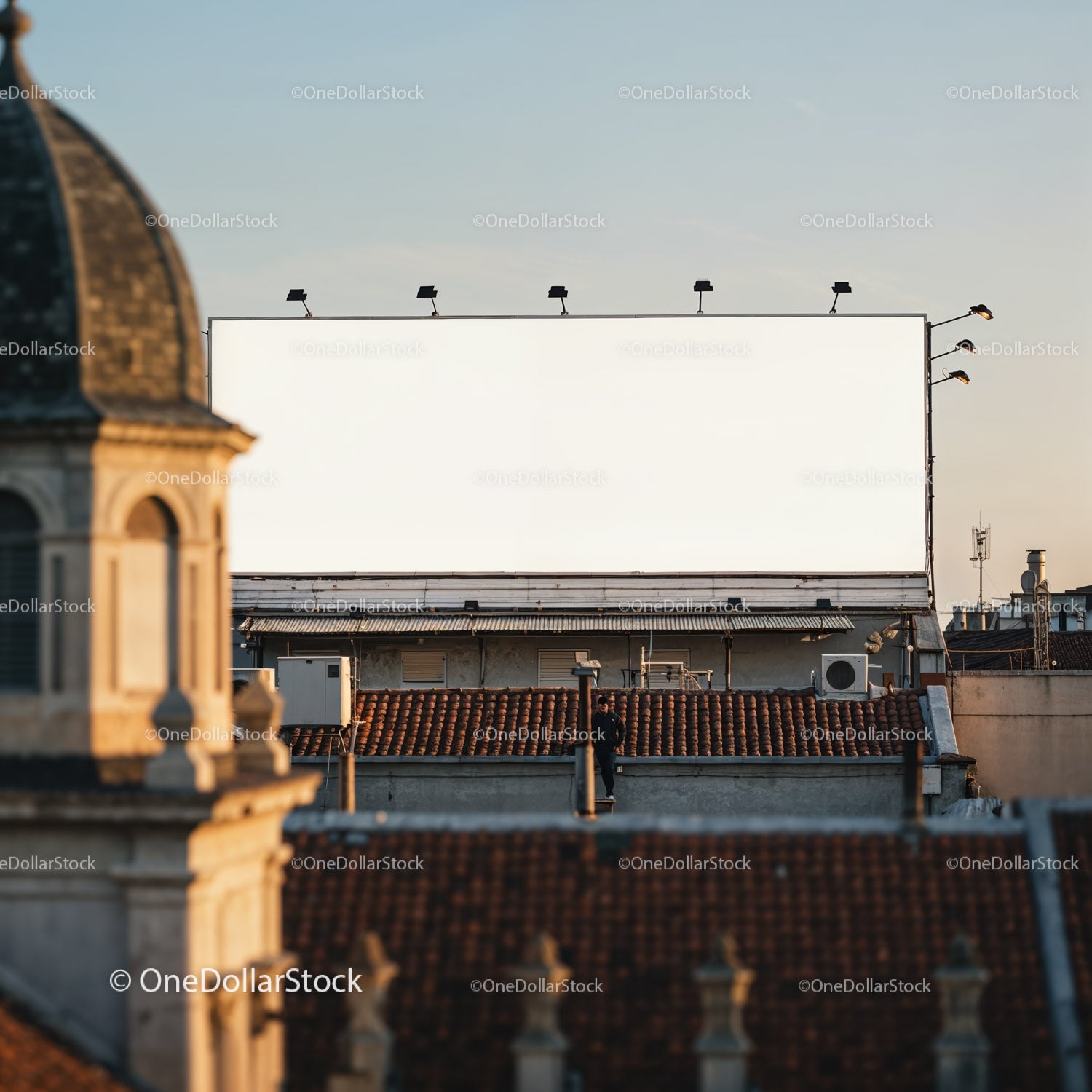 Urban rooftop with blank billboard in warm evening light
