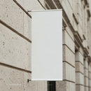 Blank white banner hanging on urban stone wall