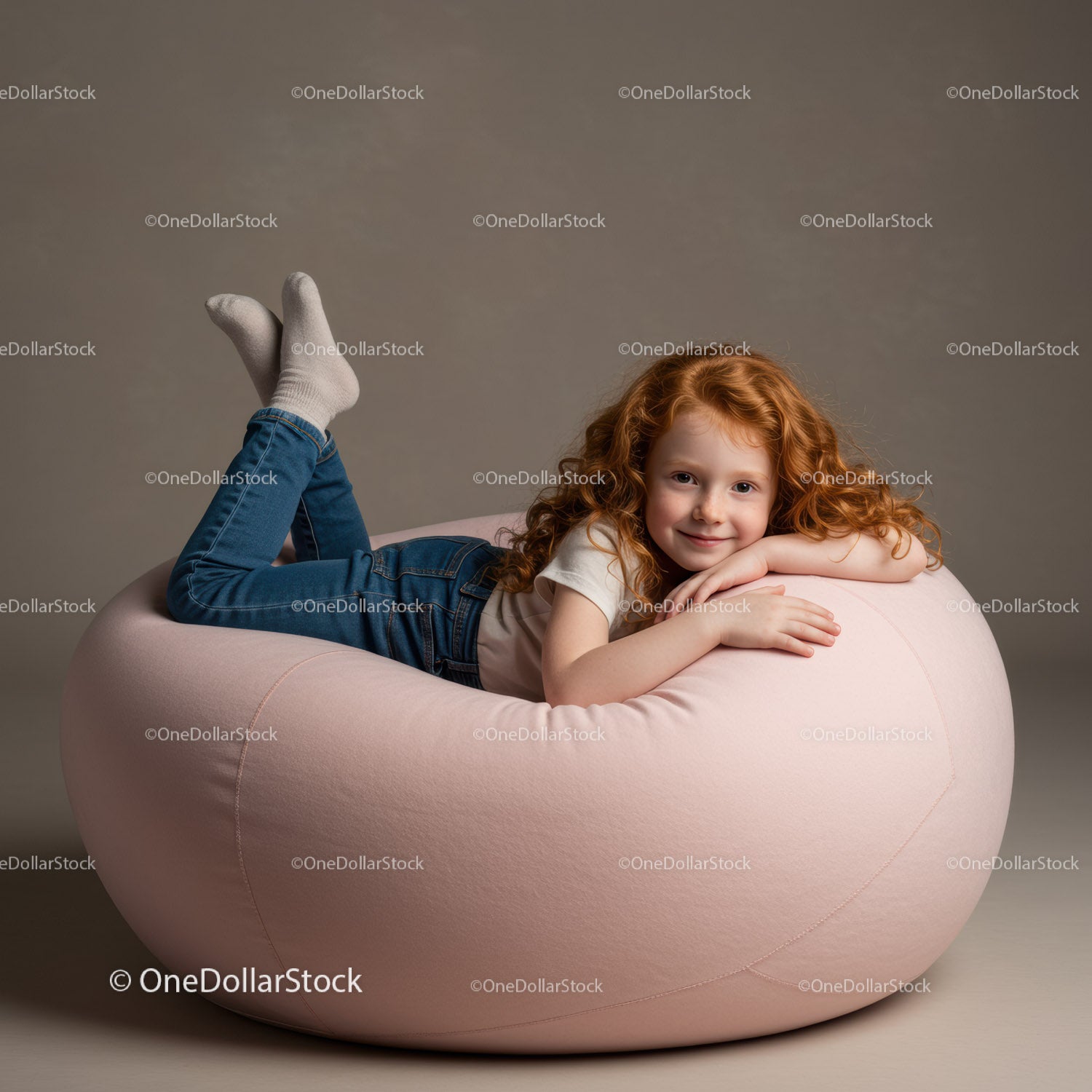 Smiling redhead girl relaxing on soft pink bean bag