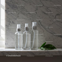 Clear Spray Bottles on Marble Surface with Green Leaves JPG Mockup Image preview