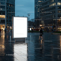 Evening city street with illuminated blank billboard