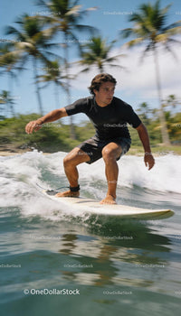 Focused man surfing a wave near tropical palm trees