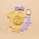 Soft yellow baby bodysuit with pastel accessories set