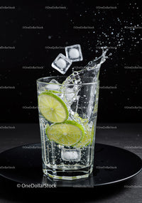 Refreshing lime slices with ice splashing in glass