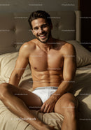 Smiling man relaxing in white briefs on beige bed