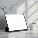 Tablet on marble table with white coffee cup