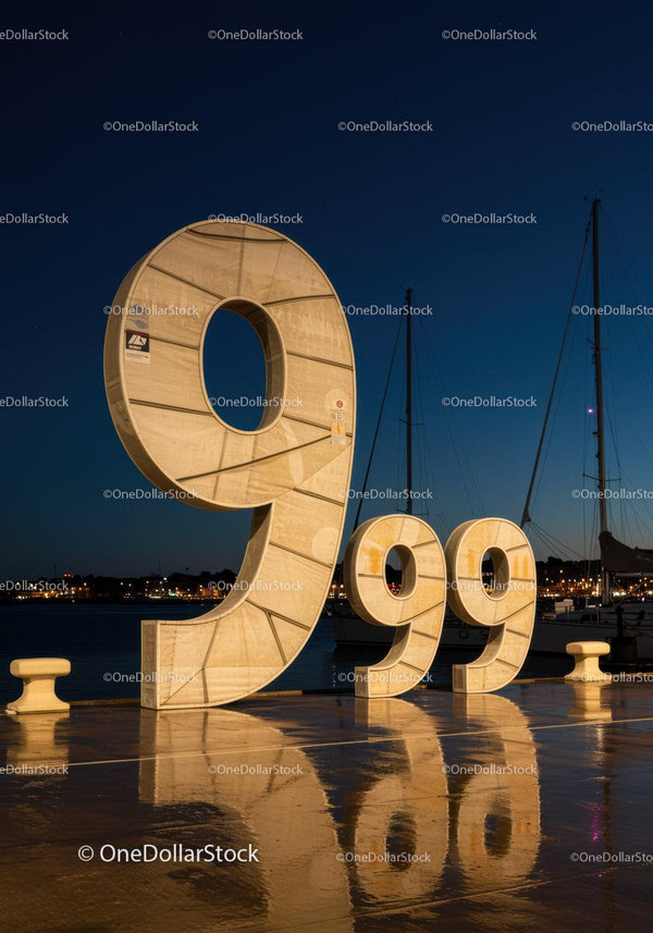 Duża podświetlana rzeźba 999 na marinie nocą