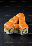 Fresh salmon sushi rolls with avocado on black slate