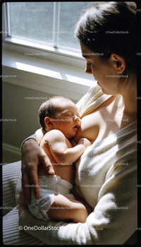 Mother Tenderly Breastfeeding Newborn by Window Light