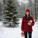Smiling woman with Christmas gifts in snowy forest