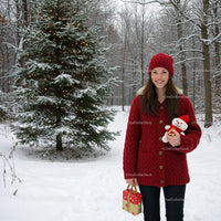 Smiling woman with Christmas gifts in snowy forest