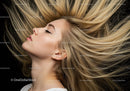 Blonde woman with flowing hair and closed eyes
