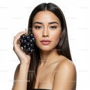 Portrait of a Beautiful Woman Holding Fresh Black Grapes in Studio