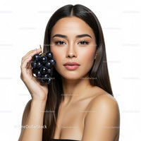 Portrait of a Beautiful Woman Holding Fresh Black Grapes in Studio