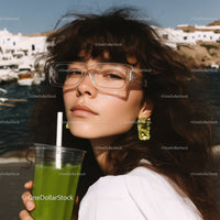 Young Woman with Wavy Hair Wearing Sunglasses Holding Green Smoothie