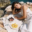 Young woman relaxing on rocks with fresh figs and lemons