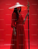 Elegant Woman in Red Dress with Accessories Against Red Background