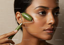 Close-up of a woman using jade facial roller for skincare and relaxation