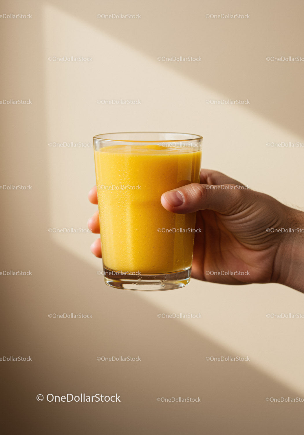 Hand Holding Fresh Glass of Orange Smoothie