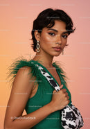 Elegant Woman in Green Dress with Feather Details and Statement Earrings