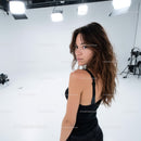 Stylish Female Model in Studio with Long Wavy Hair and Black Attire