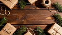 Rustic Christmas gifts with pine branches on wooden table