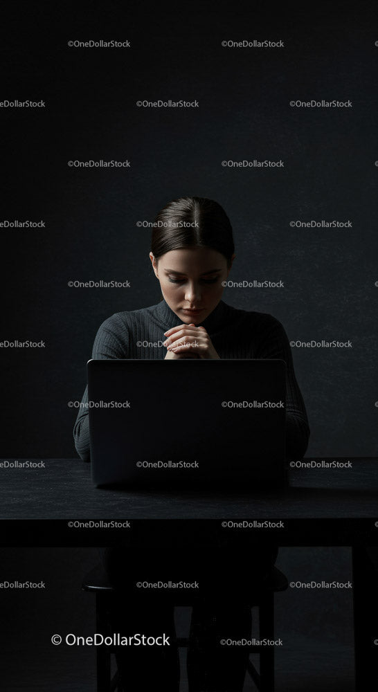 Thoughtful Woman at Laptop in Dark Modern Workspace