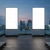 Empty illuminated billboards on city rooftop at dusk