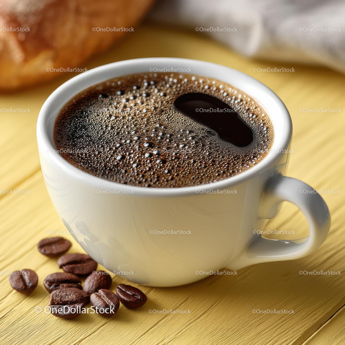 Delicious Coffee in a White Cup with Coffee Beans on Table
