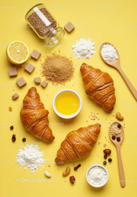 Fresh croissants with ingredients on yellow background