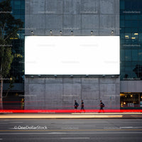 Urban street scene with large blank billboard at dusk