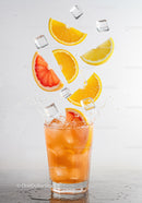 Refreshing citrus cocktail with splashing ice cubes