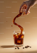 Refreshing iced coffee poured from glass on beige background