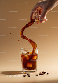 Refreshing iced coffee poured from glass on beige background
