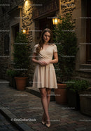 Elegant Young Woman in Beige Dress Standing on City Street at Dusk