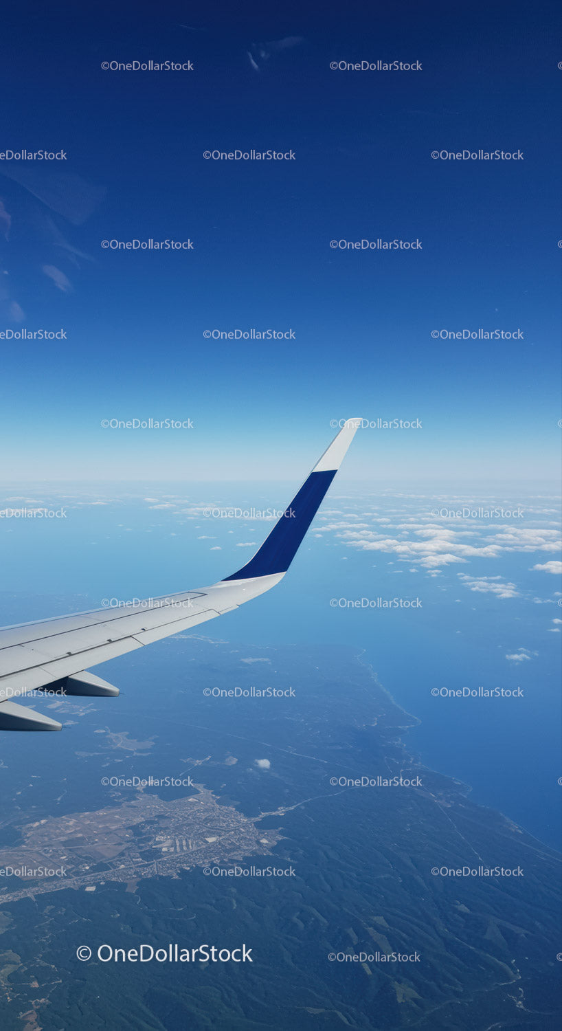 Aerial View of Airplane Wing Over Mountains and Cloudscape