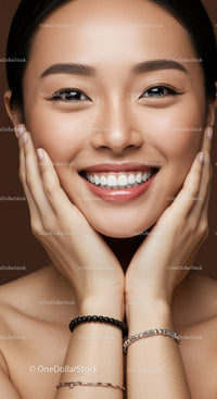 Close up portrait of smiling young woman with hands on face