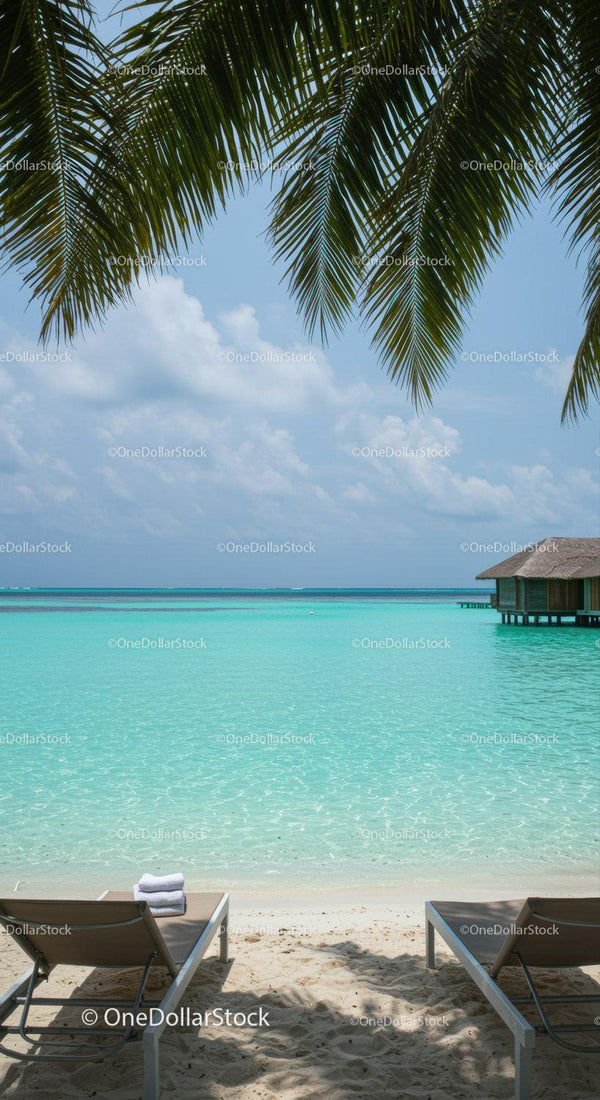 Tropical Beach with Overwater Bungalow and Lounge Chairs Under Palm Tree