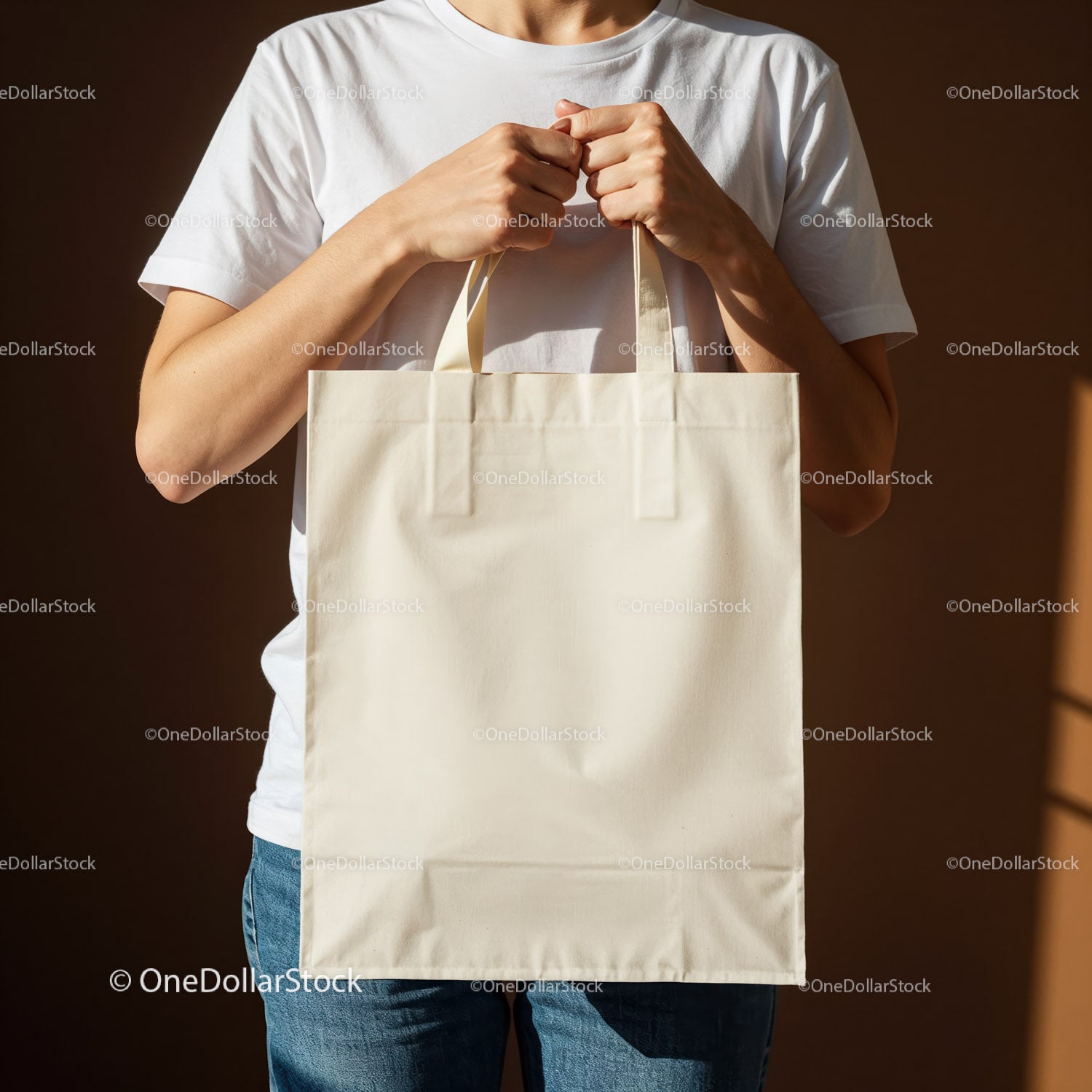 Person holding blank beige tote bag in sunlight