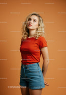 Young woman in red t-shirt looking up thoughtfully