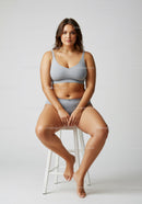 Confident Plus Size Woman Sitting in Casual Sportswear on Stool