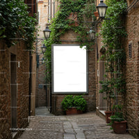 Narrow cobblestone street with blank billboard and greenery