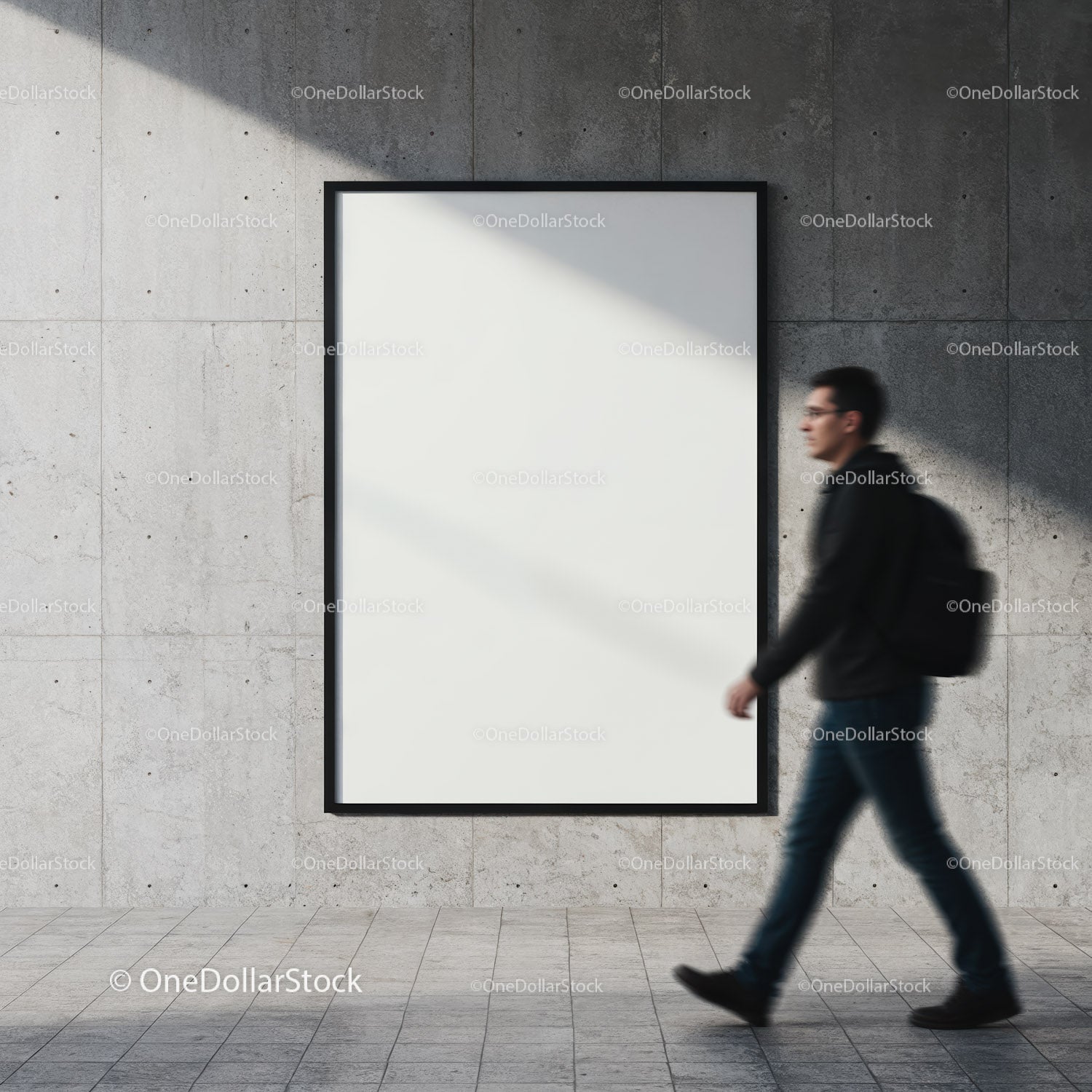Man walking past blank poster on concrete wall