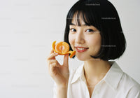 Young Woman Smiling with Orange Peel in Bright Studio Setting