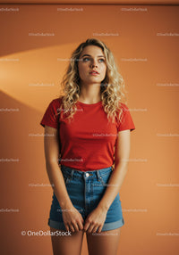 Young woman in red t-shirt and denim shorts posing indoors